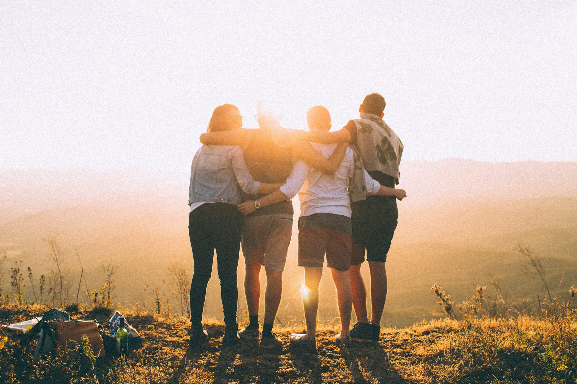 group of four people in front of sunset